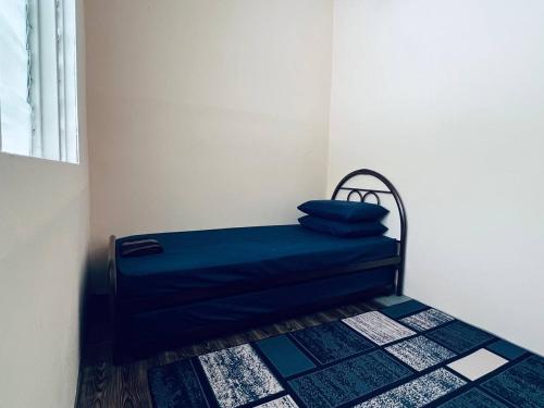 a bed in a room with a blue pillow on it at Inap Desa R'Sawit Pintu B in Sekincan