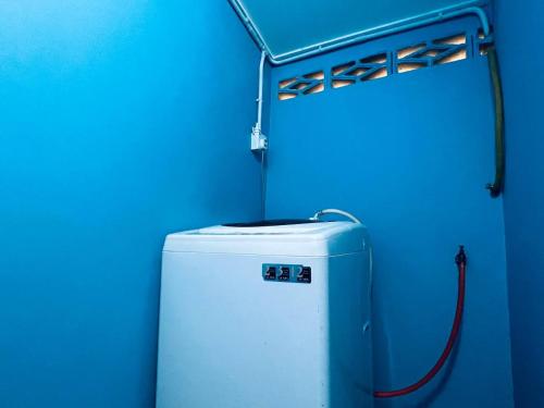a refrigerator in a room with a blue wall at Inap Desa R'Sawit Pintu B in Sekincan