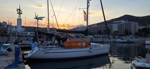 un barco está atracado en un puerto deportivo con la puesta de sol en Yacht Pipit, en Kavala