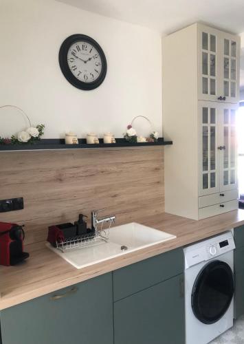 a kitchen with a sink and a clock on the wall at Bella Villa in Balatonalmádi