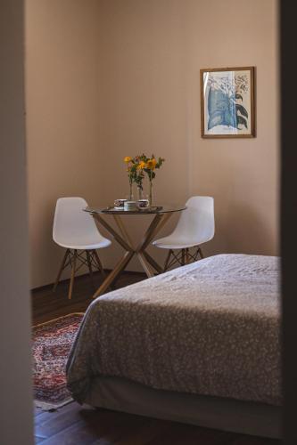 a room with a table and two chairs and a bed at Residenza D'Epoca Il Grifoncello in Montepulciano
