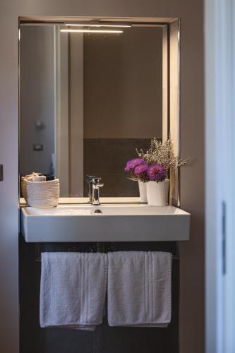 a bathroom sink with towels and a mirror at Residenza D'Epoca Il Grifoncello in Montepulciano