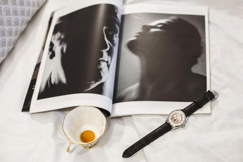 a book with a magnifying glass and a watch and a cup of coffee at Residenza D'Epoca Il Grifoncello in Montepulciano
