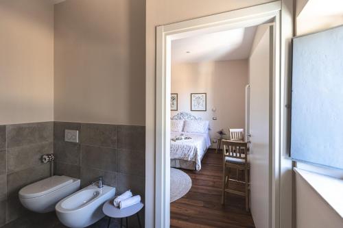 a bathroom with a sink and a toilet and a bedroom at Residenza D'Epoca Il Grifoncello in Montepulciano