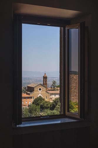 an open window with a view of a building at Residenza D'Epoca Il Grifoncello in Montepulciano