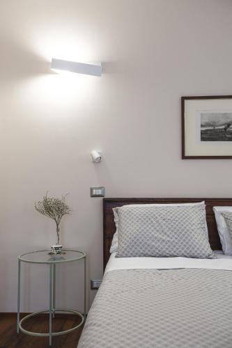 a bedroom with a bed with a table next to it at Residenza D'Epoca Il Grifoncello in Montepulciano