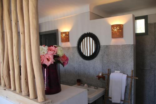 a bathroom with a sink and a vase of flowers at Kasbah Beldi in Lalla Takerkoust