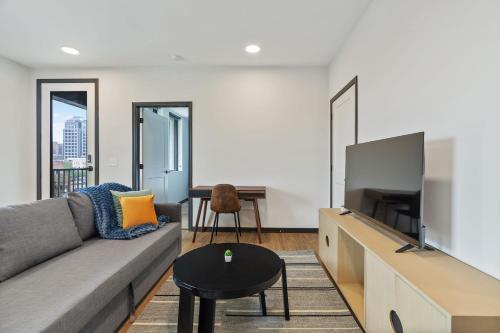 a living room with a couch and a flat screen tv at CozySuites on Mass with garage parking #7 in Indianapolis