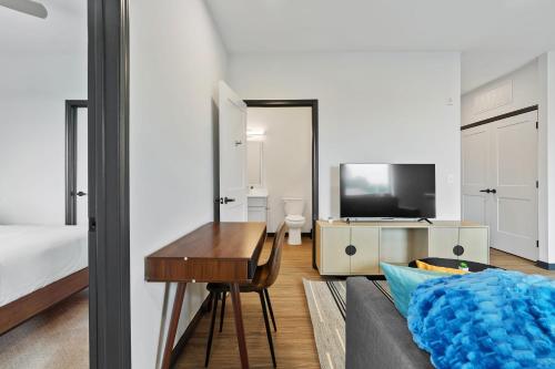 a bedroom with a bed and a table and a television at CozySuites on Mass with garage parking #7 in Indianapolis