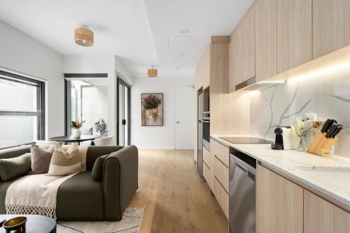 a kitchen and living room with a couch and a table at The Henrietta Apartments by Urban Rest in Sydney