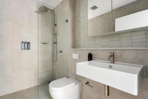 a bathroom with a sink and a toilet at The Henrietta Apartments by Urban Rest in Sydney