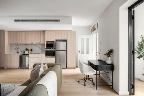 a living room with a couch and a desk at The Henrietta Apartments by Urban Rest in Sydney