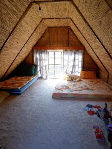 a attic room with two beds and a window at Casa Valer Arieseni in Arieşeni