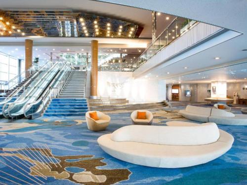 a cruise ship lobby with escalators and couches at Lake Biwa Otsu Prince Hotel in Otsu