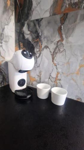 a coffee maker and two cups on a table at Studio des 3 frontières in Huningue