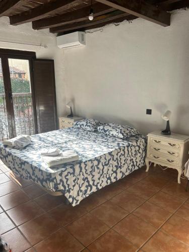 a bedroom with a bed and two night stands and a window at La Posada De Alanah in Candeleda