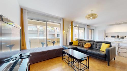 un salon avec un canapé et une table dans l'établissement Les terrasses de Saint Georges 100m clim Parking, à Toulouse