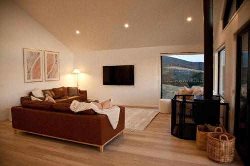 a living room with a couch and a tv at Bruny Island Sunset Retreat in Alonnah