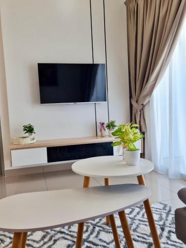 a living room with a white table and a tv at Bayu Temiang Residensi in Seremban