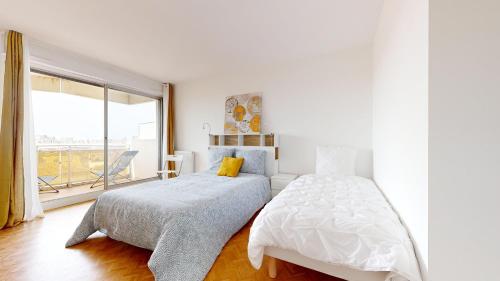 une chambre blanche avec un lit et une fenêtre dans l'établissement Les terrasses de Saint Georges 100m clim Parking, à Toulouse