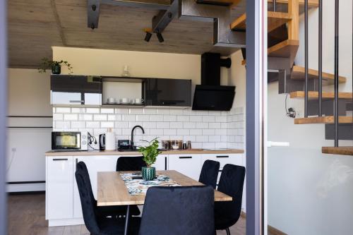 a kitchen and dining room with a table and chairs at Gospodarstwo Agroturystyczne Borówkowy Bukiet Smaków in Iwkowa