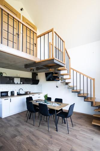 a kitchen and dining room with a wooden table and chairs at Gospodarstwo Agroturystyczne Borówkowy Bukiet Smaków in Iwkowa