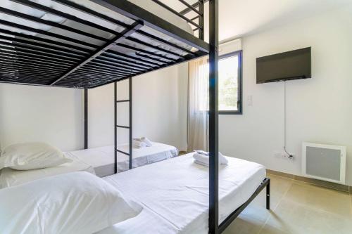 une chambre avec deux lits et une télévision à écran plat dans l'établissement SELECT'soHOME - Appartement pour 5 personnes idéalement situé à proximité de la plage et des commerces de La Favière ! - ILOA-B04, à Bormes-les-Mimosas