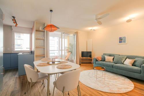 un salon avec une table et un canapé dans l'établissement Appartement raffiné, veranda et parking, Lyon 3, à Lyon