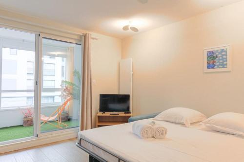 une chambre avec un lit, une télévision et une fenêtre dans l'établissement Appartement raffiné, veranda et parking, Lyon 3, à Lyon