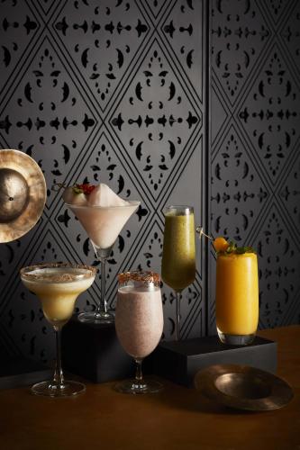 a group of cocktails sitting on a table in front of a wall at Hyatt Regency Bangkok Sukhumvit in Bangkok