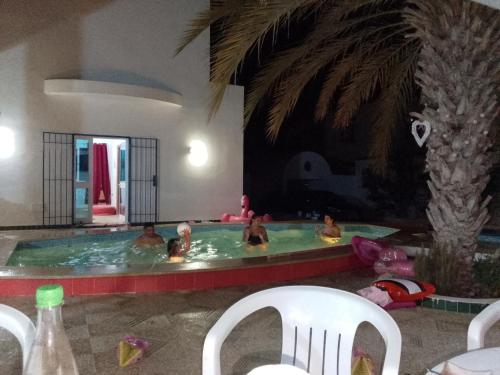 a group of people in a swimming pool at Casa loud in Sidi el Moujahed