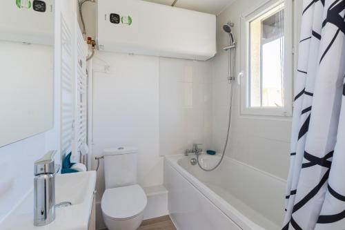 une salle de bain blanche avec toilettes et douche dans l'établissement Duplex du bord de mer - Appt à 50m de la plage, à Villers-sur-Mer