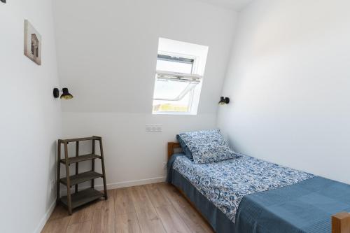 une petite chambre avec un lit et une fenêtre dans l'établissement Duplex du bord de mer - Appt à 50m de la plage, à Villers-sur-Mer