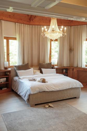 a bedroom with a large bed with a chandelier at Hotel-Restaurant Kreuzberghof Tagungs- und Veranstaltungshotel in Tiefenbach