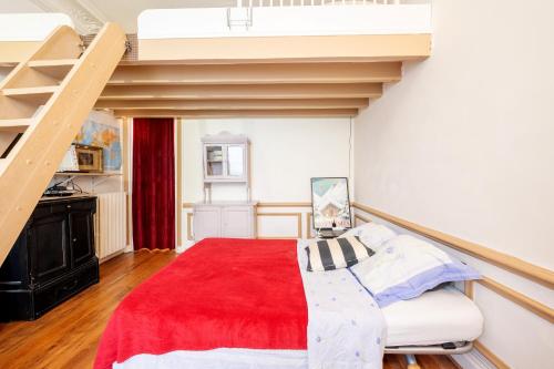 une chambre avec un lit avec une couverture rouge dans l'établissement Rubis - Joli T2 dans le 10e arrondissement Paris, à Paris