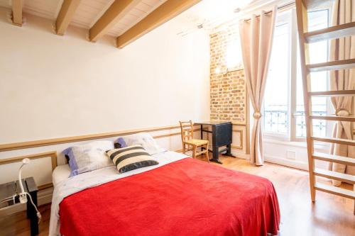 une chambre avec un lit avec une couverture rouge dans l'établissement Rubis - Joli T2 dans le 10e arrondissement Paris, à Paris