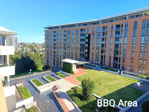 a large building with a park in front of it at Luxury Condo 2Bedrooms near Olympic Park CBD in Sydney
