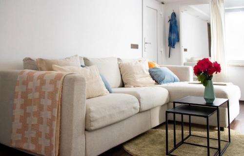 a living room with a white couch and a vase of flowers at Gemütliche Ferienwohnung & Garten in Sankt Johann