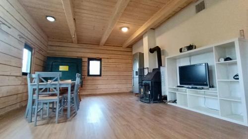 a living room with a television and a table and chairs at Roubenky za Hurtovnou in Orlické Záhoří 