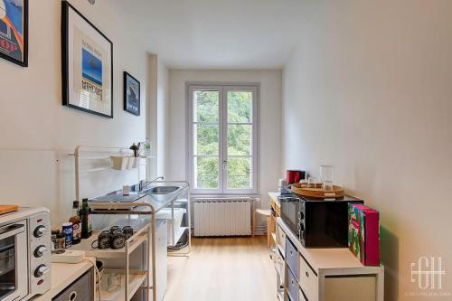 une cuisine avec une cuisinière et une fenêtre. dans l'établissement L'Hoya - Quartier Prébendes, à Tours