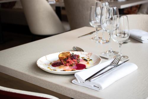 a plate of food on a table with wine glasses at Brit Hotel Nantes La Beaujoire Parc Expo in Nantes
