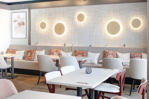 a dining room with white tables and chairs at Brit Hotel Nantes La Beaujoire Parc Expo in Nantes
