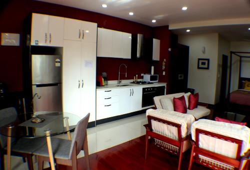 a kitchen and living room with a couch and a table at Kia Orana Villas and Spa in Rarotonga