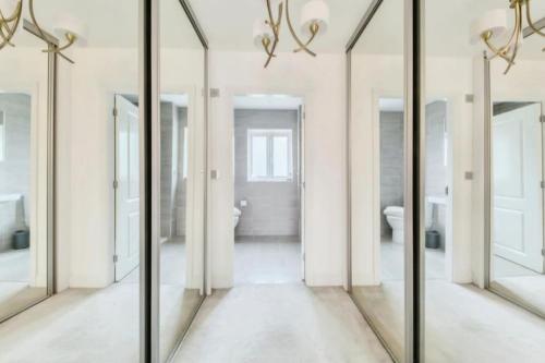 a hallway with mirrors in a bathroom at Cheshire home by Chelsea in Macclesfield