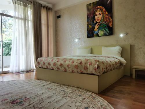 a bedroom with a bed with a painting on the wall at Panorama Green View Hotel Nuwara Eliya in Nuwara Eliya