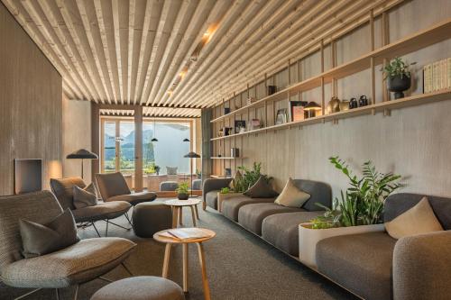 a waiting room with couches and chairs and tables at PANORAMA Allgäu Spa Resort in Seeg