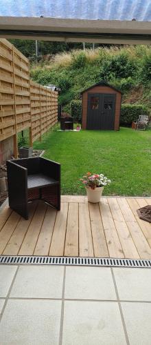 a wooden deck with a bench and a pot of flowers at Au petit 31 in Pepinster