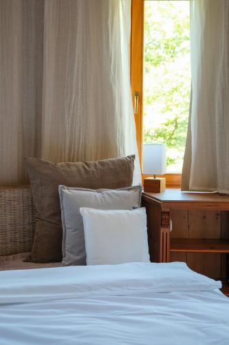 a bed with two pillows sitting next to a window at Hotel-Restaurant Kreuzberghof Tagungs- und Veranstaltungshotel in Tiefenbach