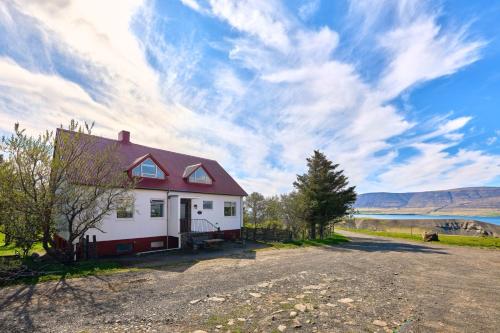 a house on the side of a road next to a lake at Kidafell Farmhouse in Mosfellsbær