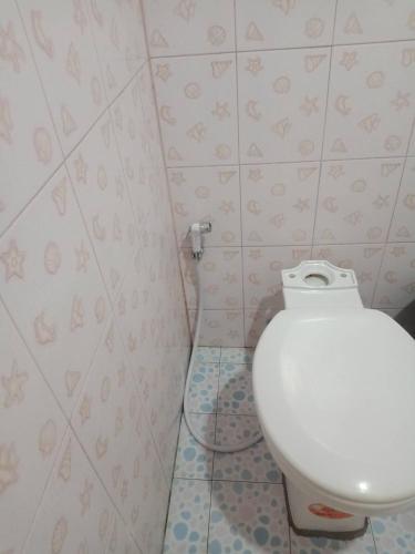 a bathroom with a white toilet in a room at มังกรเลโฮสเทล Mangkonlay Hostel in Ban Khlong Pak